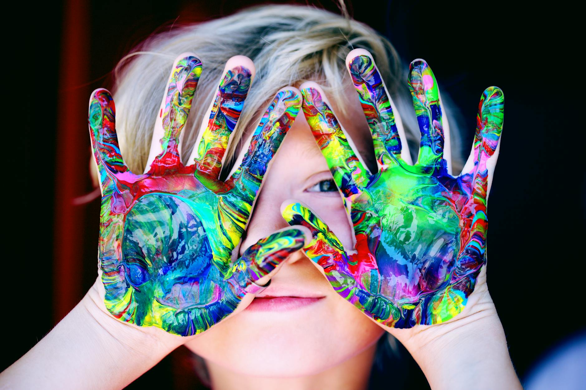 a kid with multicolored hand paint